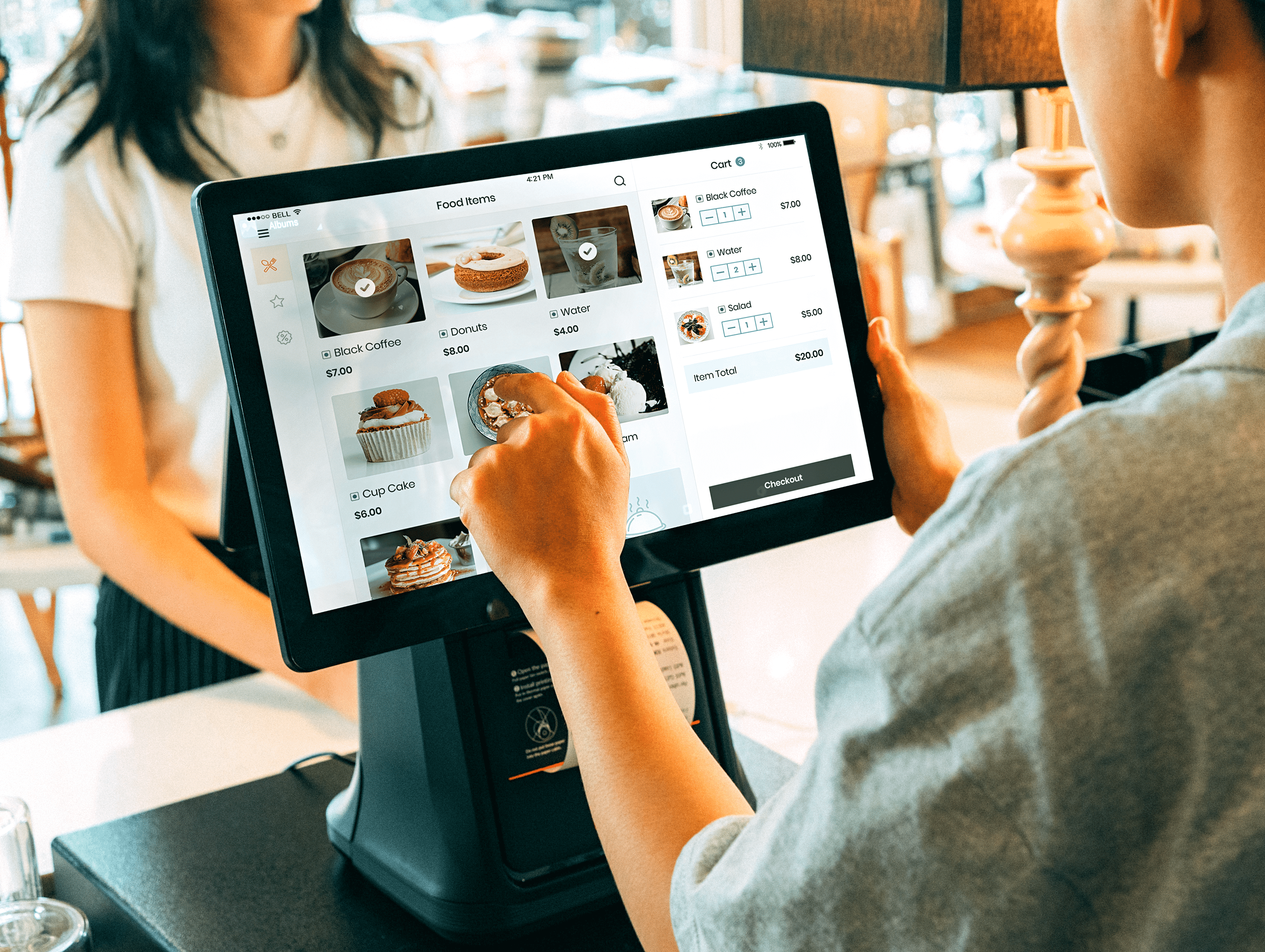 storefront business; point-of-sale tablet displayed; one person operates the device while the other person looks ahead